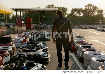 Man preparing for race day at the GoKart track for an exhilarating experience Man preparing for race day at the GoKart track for an exhilarating experience 134450475