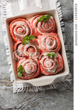 Homemade pink cinnamon rolls with cream cheese in a baking dish. Vertical top view 134450658