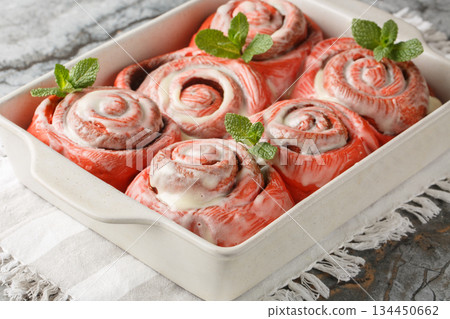 Festive pink cinnabon roll French buns with cinnamon and cream closeup on the plate. horizontal Festive pink cinnabon roll French buns with cinnamon and cream closeup on the plate. horizontal 134450662