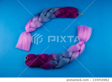 Colored braids on a blue background. Colored braids on a blue background. 134450962