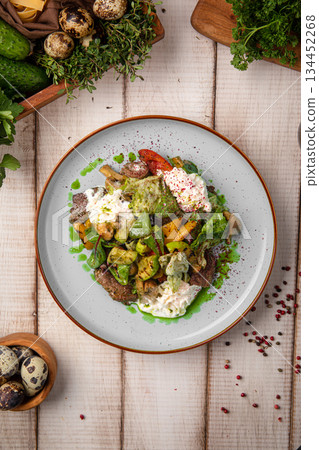 Warm beef salad with vegetables and egg 134452268