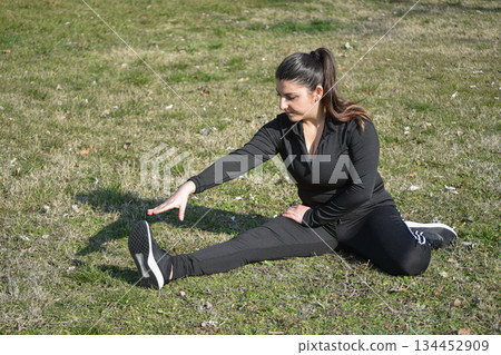 Woman with visual disabilities exercising in the park and stretching Woman with visual disabilities exercising in the park and stretching 134452909