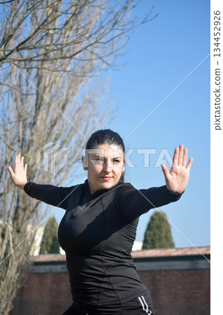 Woman with visual disabilities exercising in the park and stretching 134452926
