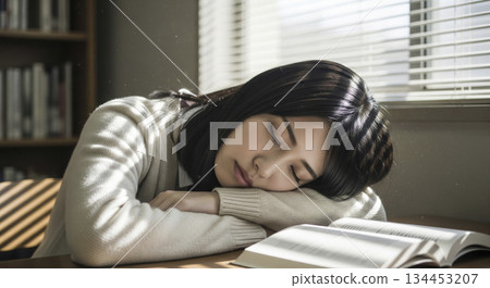 A woman sleeping in a library 134453207