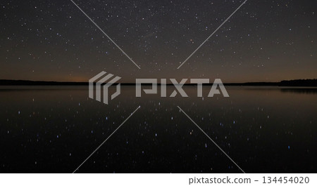 A starry sky reflected on the mirror-like surface of the water A starry sky reflected on the mirror-like surface of the water 134454020