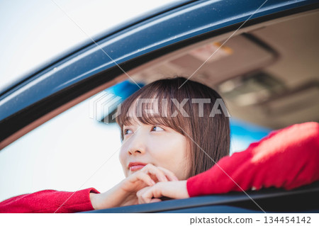 一位長髮年輕女子在汽車副駕駛座上玩得很開心 134454142