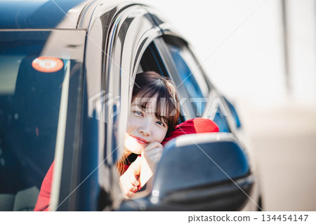 一位長髮年輕女子在汽車副駕駛座上玩得很開心 134454147