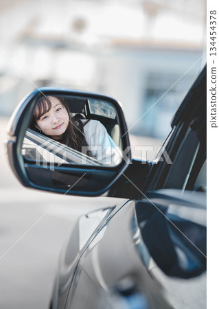 Young woman through the side mirror Young woman through the side mirror 134454378
