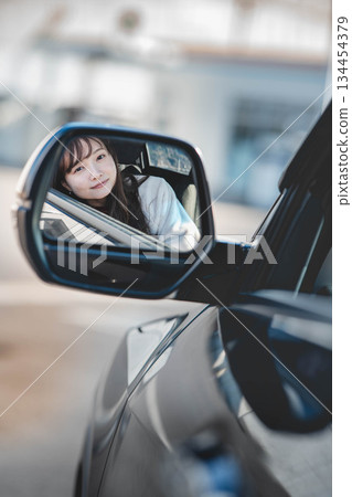 透過後視鏡看到的年輕女子 透過後視鏡看到的年輕女子 134454379