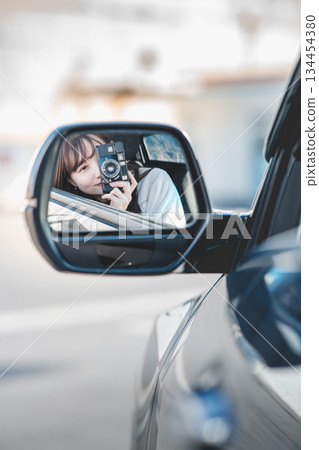 Young woman through the side mirror 134454380