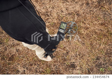 Information on the display. Man is with metal detector in the field 134454674