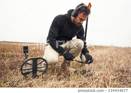 Old bullet, rusty material. Man is with metal detector in the field 134454677