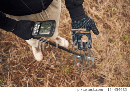 Old bullets and coin. Man is with metal detector in the field Old bullets and coin. Man is with metal detector in the field 134454683