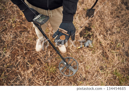 Old bullets and coin. Man is with metal detector in the field Old bullets and coin. Man is with metal detector in the field 134454685