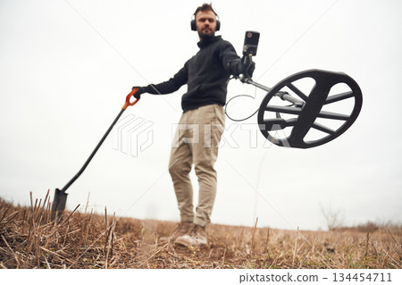 View from below. Man is with metal detector in the field View from below. Man is with metal detector in the field 134454711