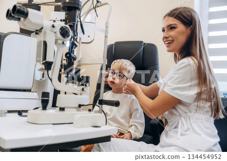 Trying new glasses. Little boy is having check up in the ophthalmologist cabinet Trying new glasses. Little boy is having check up in the ophthalmologist cabinet 134454952