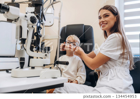 Trying new glasses. Little boy is having check up in the ophthalmologist cabinet Trying new glasses. Little boy is having check up in the ophthalmologist cabinet 134454953