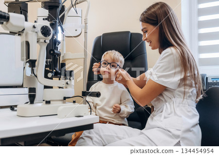 Trying new glasses. Little boy is having check up in the ophthalmologist cabinet Trying new glasses. Little boy is having check up in the ophthalmologist cabinet 134454954