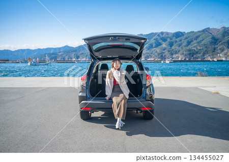 在陽光明媚的日子裡，一位年輕女子開車前往海邊。 134455027