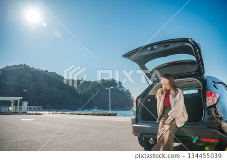 在陽光明媚的日子裡，一位年輕女子開車前往海邊。 134455039