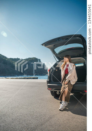 A young woman driving to the sea on a sunny day A young woman driving to the sea on a sunny day 134455041