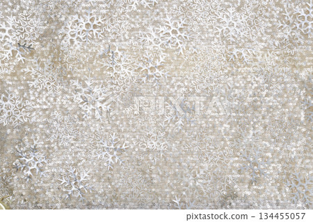 Abstract winter background featuring silver snowflake patterns and subtle glitter texture on a neutral beige surface, suitable for holiday design, seasonal themes, and decorative use. Abstract winter background featuring silver snowflake patterns and subtle glitter texture on a neutral beige surface, suitable for holiday design, seasonal themes, and decorative use. 134455057
