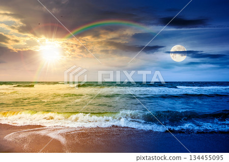 sea waves crashing sandy beach. day and night time change concept. summer solstice on a windy weather under cloudy sky with sun and moon. view of dramatic seascape. duality and transition template 134455095