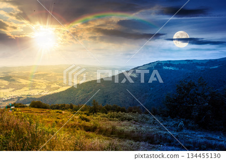 mountain landscape of under blue sky with clouds. day and night time change concept. countryside scenery with green meadow, rolling hills and valley under sun and moon. duality and transition template 134455130