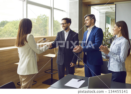 Group of business people meeting in office, making agreements and exchanging handshakes Group of business people meeting in office, making agreements and exchanging handshakes 134455141