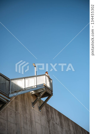 年輕女子坐在階梯上，仰望著天空。 134455302