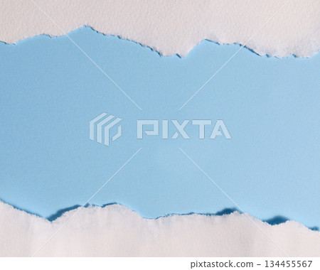 Torn white paper creating border on light blue background with empty copy space for design or text Torn white paper creating border on light blue background with empty copy space for design or text 134455567