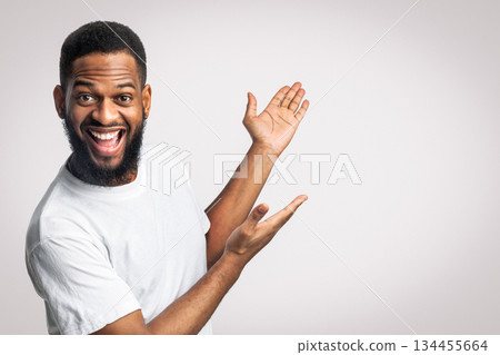 Joyful Bearded Black Man Gesturing Showing Free Space For Text Aside Standing In Studio Over White Background. Advertisement Banner. Look At This, Great Offer Concept. Panorama Joyful Bearded Black Man Gesturing Showing Free Space For Text Aside Standing In Studio Over White Background. Advertisement Banner. Look At This, Great Offer Concept. Panorama 134455664