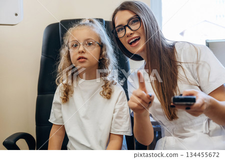 Looking forward. Little girl at the ophthalmologist clinic with doctor 134455672