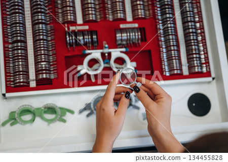 Ophthalmologist is picking different lenses that are in the kit Ophthalmologist is picking different lenses that are in the kit 134455828
