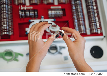 Ophthalmologist is picking different lenses that are in the kit Ophthalmologist is picking different lenses that are in the kit 134455829