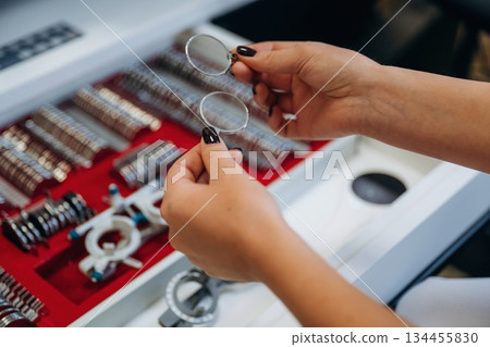 Ophthalmologist is picking different lenses that are in the kit 134455830