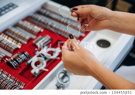 Ophthalmologist is picking different lenses that are in the kit 134455831