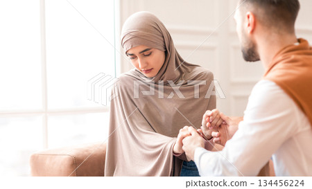 Unanswered Love. Unhappy Muslim Woman Saying No To Marriage Proposal Of Her Boyfriend, Holding Hands Sitting On Sofa At Home. Relationship Problem, Forced Marriage Concept. Selective Focus Unanswered Love. Unhappy Muslim Woman Saying No To Marriage Proposal Of Her Boyfriend, Holding Hands Sitting On Sofa At Home. Relationship Problem, Forced Marriage Concept. Selective Focus 134456224