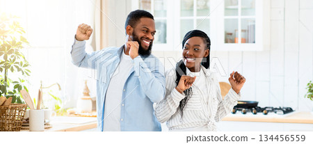 Home Date. Portrait Of Joyful Black Couple Dancing In Kitchen After Romantic Lunch, Cheerful African American Spouses Drinking Red Wine And Having Fun, Enjoying Spending Time Together, Free Space Home Date. Portrait Of Joyful Black Couple Dancing In Kitchen After Romantic Lunch, Cheerful African American Spouses Drinking Red Wine And Having Fun, Enjoying Spending Time Together, Free Space 134456559