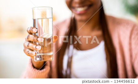 Unrecognizable Black Woman Offering Glass Of Water To Camera, Positive Young African American Female Recommending Healthy Refreshing Drink For Body Hydration, Closeup Shot, Cropped Image Unrecognizable Black Woman Offering Glass Of Water To Camera, Positive Young African American Female Recommending Healthy Refreshing Drink For Body Hydration, Closeup Shot, Cropped Image 134456612