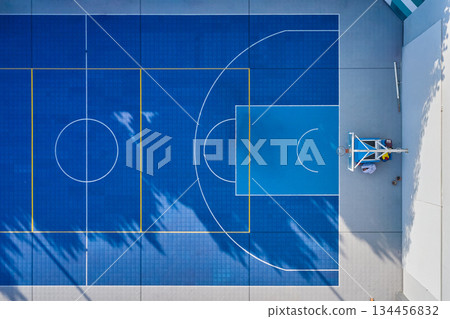 Blue basketball court aerial view with palm tree shadows 134456832