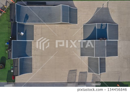 Aerial view of skatepark with bmx rider on concrete ramp 134456846