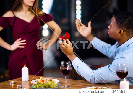 African American Man Begging His White Girlfriend To Marry Him While Having Date In Restaurant, Black Boyfriend Making Marriage Proposal, Stubborn Woman Not Accepting His Offer, Selective Focus 134456901