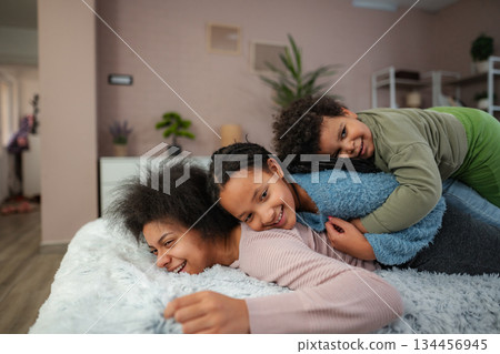 Mother and children laughing, playing, and bonding at home 134456945