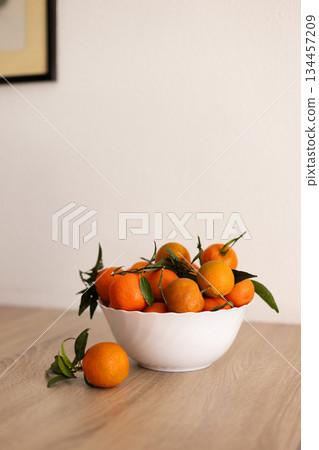 Full bowl of fresh tangerine on a wooden table. 134457209