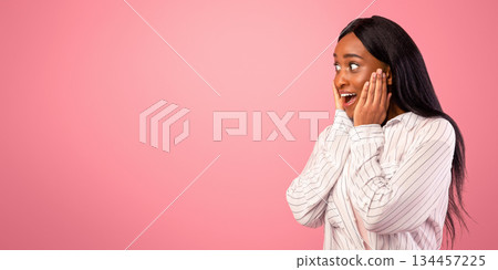 Excited African American woman looking at blank space on pink studio background, panorama. Emotional young black lady advertising or promoting your product or service, having special offer 134457225