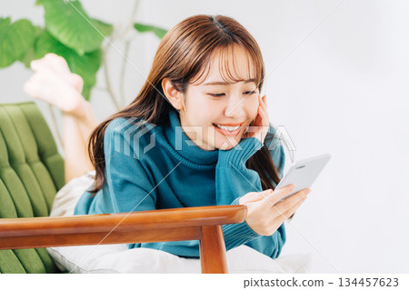 躺在沙發上使用智能手機的女人 134457623