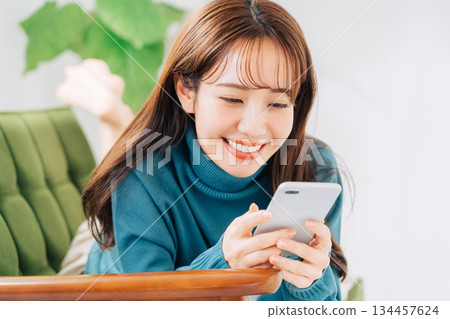 躺在沙發上使用智能手機的女人 134457624