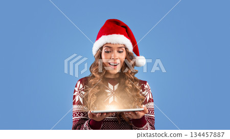 Lovely millennial lady in winter outfit with tablet computer shocked over huge Christmas sale in online store on blue studio background, panorama. Shopping for Xmas and New Year concept Lovely millennial lady in winter outfit with tablet computer shocked over huge Christmas sale in online store on blue studio background, panorama. Shopping for Xmas and New Year concept 134457887