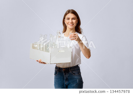 Reuse Of Waste Materials. Portraif Of Smiling Millennial Woman Holding Wooden Box With Empty Glass Bottles For Recycling, Young Enviromental Activist Lady Enjoying Sorting Garbage, Copy Space 134457978